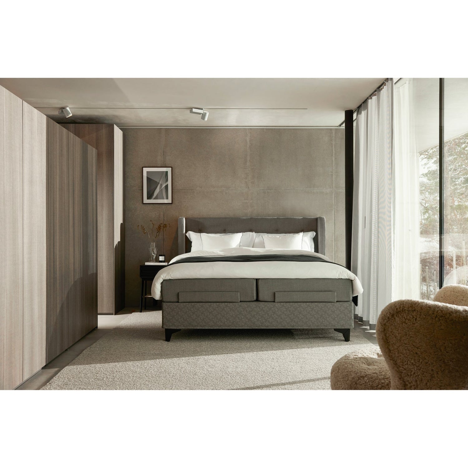 Jensen Majestic Aqtive II -moottorisänky on Nest-sängynpäädyn kanssa sisustuksellinen kokonaisuus, kuvassa on harmaa verhoiluväri ja mustat Eicon-jalat. Jensenin sängynpääty ja musta Eicon-yöpöytä myydään erikseen.