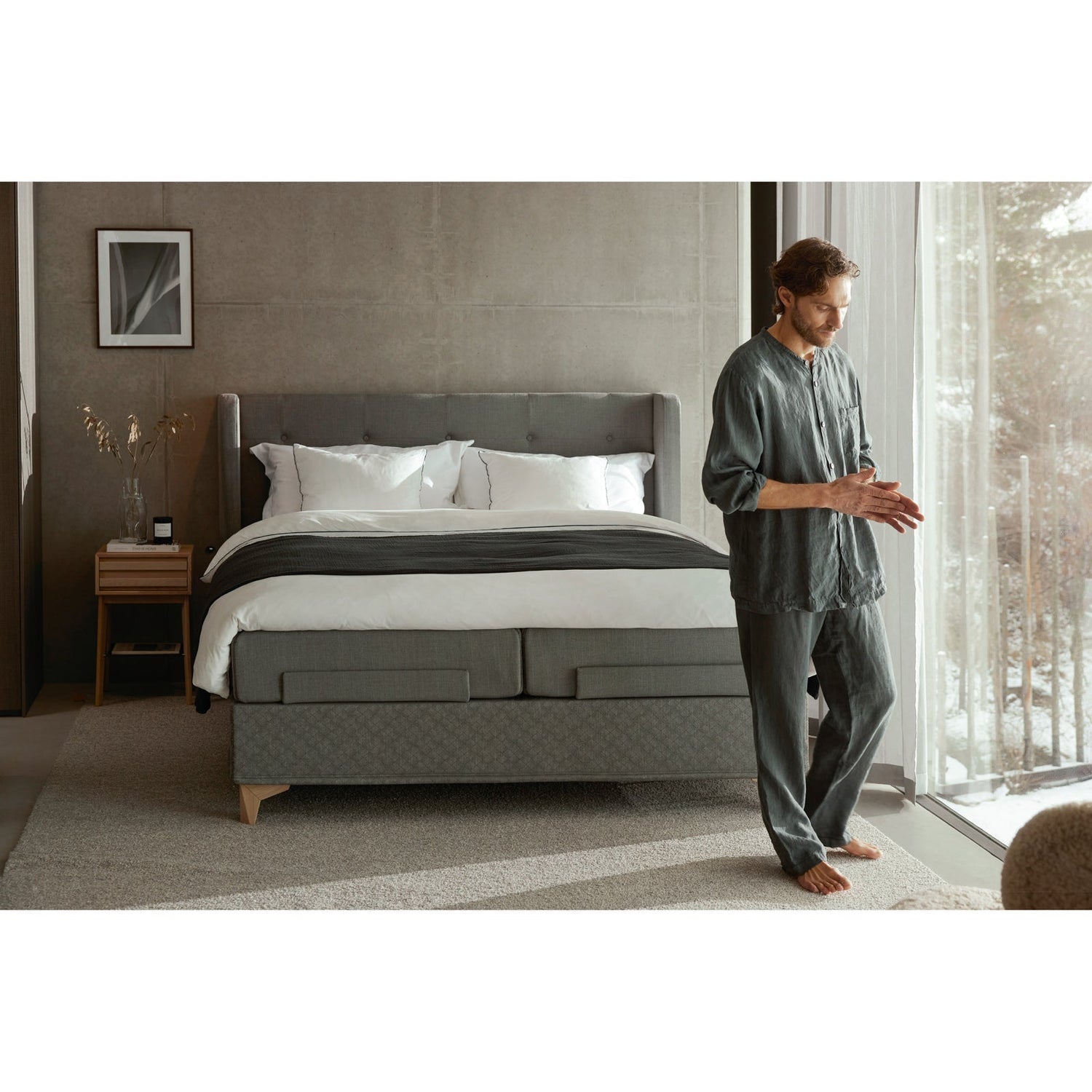 Jensen Majestic Aqtive II -moottorisänky on Nest-sängynpäädyn kanssa sisustuksellinen kokonaisuus, kuvassa on harmaa verhoiluväri ja valkotammenväriset Eicon-jalat. Jensenin sängynpääty valkotammenvärinen Eicon-yöpöytä myydään erikseen.