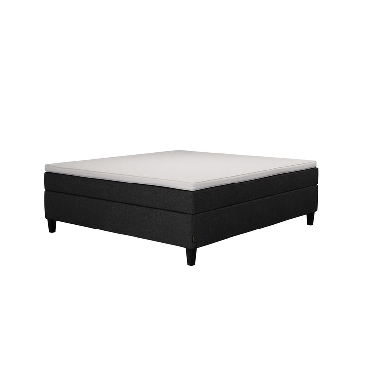 Jensen Nova Max -jenkkisängyn musta verhoiluväri ja nelikulmaiset 14 cm korkeat mustat tammijalat. Sleep 1 -sijauspatja ja jalat sisältyvät hintaan.