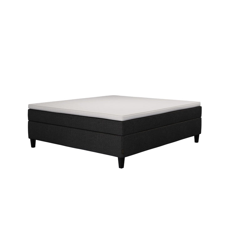 Jensen Nova Max -jenkkisängyn musta verhoiluväri ja nelikulmaiset 14 cm korkeat mustat tammijalat. Sleep 1 -sijauspatja ja jalat sisältyvät hintaan.