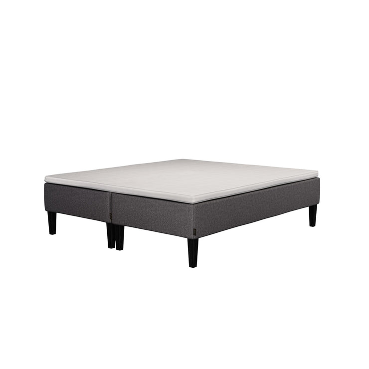 Jensen Nova Max -runkopatjasängyn tummanharmaa verhoiluväri ja nelikulmaiset 23 cm korkeat mustat tammijalat. Yhtenäinen Sleep 1 -sijauspatja ja jalat sisältyvät hintaan.