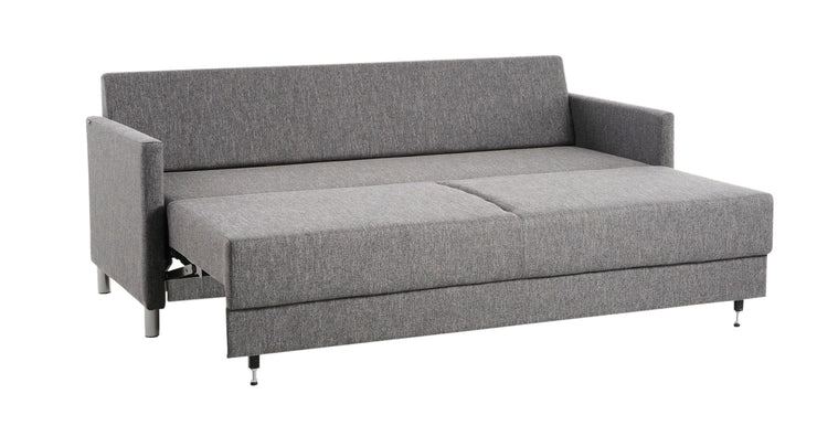 Lilja-vuodesohva antrasiitin värisellä Verde 19 -kankaalla. Kuvassa sohvan vuodemekanismi on avattuna, vuodekoko 188 x 133 cm. Kuvan sohva on poikkeuksellisesti kuvattu vakiona sohvaan kuuluvien mustien puujalkojen sijaan 10 cm korkeilla metallijaloilla.