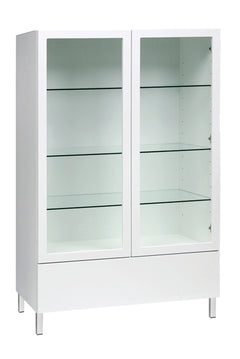 Kuvassa on 92 cm leveä korkeakiiltovalkoinen Lumo-vitriini valkoisilla metallijaloilla. Sarjan tuotteissa on valkoinen lasikansi.