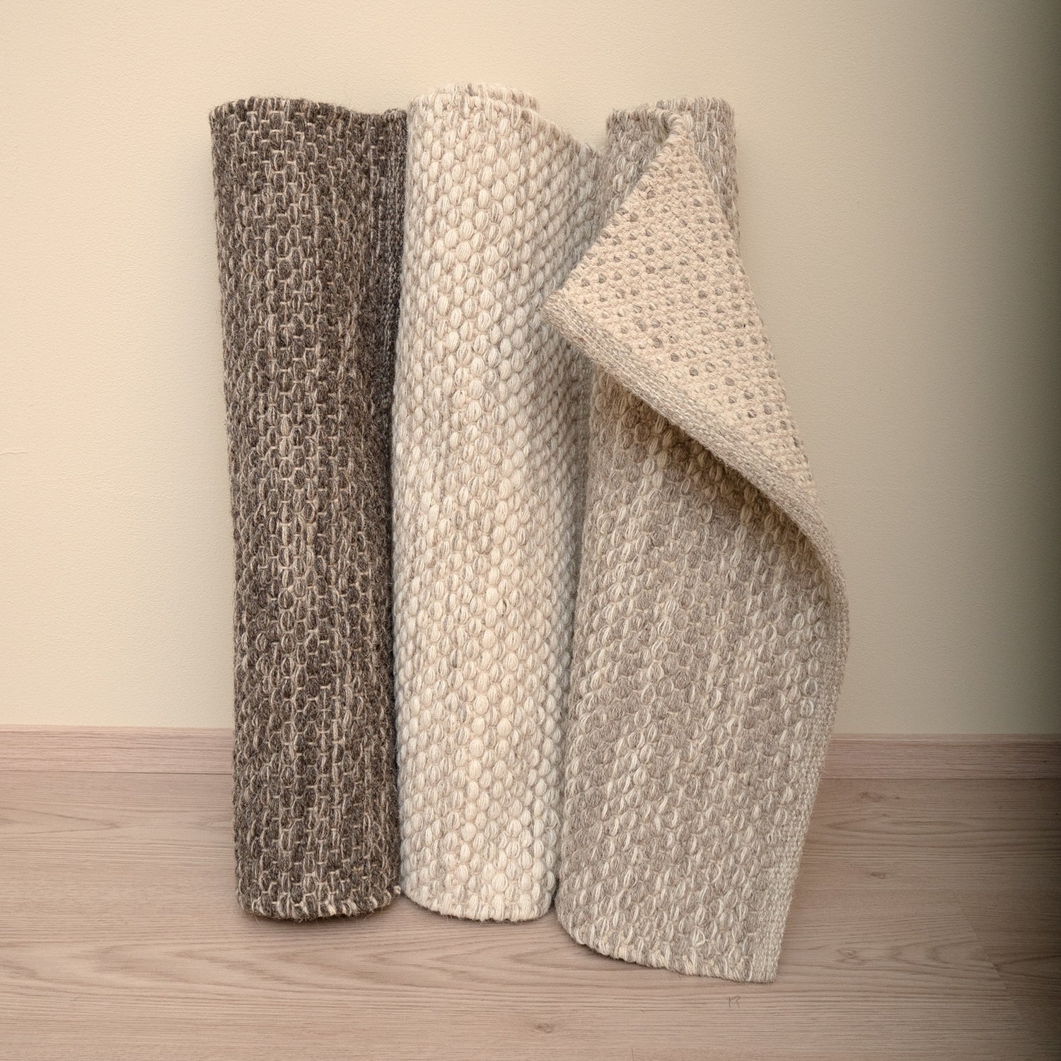 Käsinkudottu villamatto Oona on saatavana luonnollisen pehmeissä sävyissä tummanharmaana, luonnonvalkoisena ja harmaana. Oona-matossa on pelkistetty meleerattu kuosi.