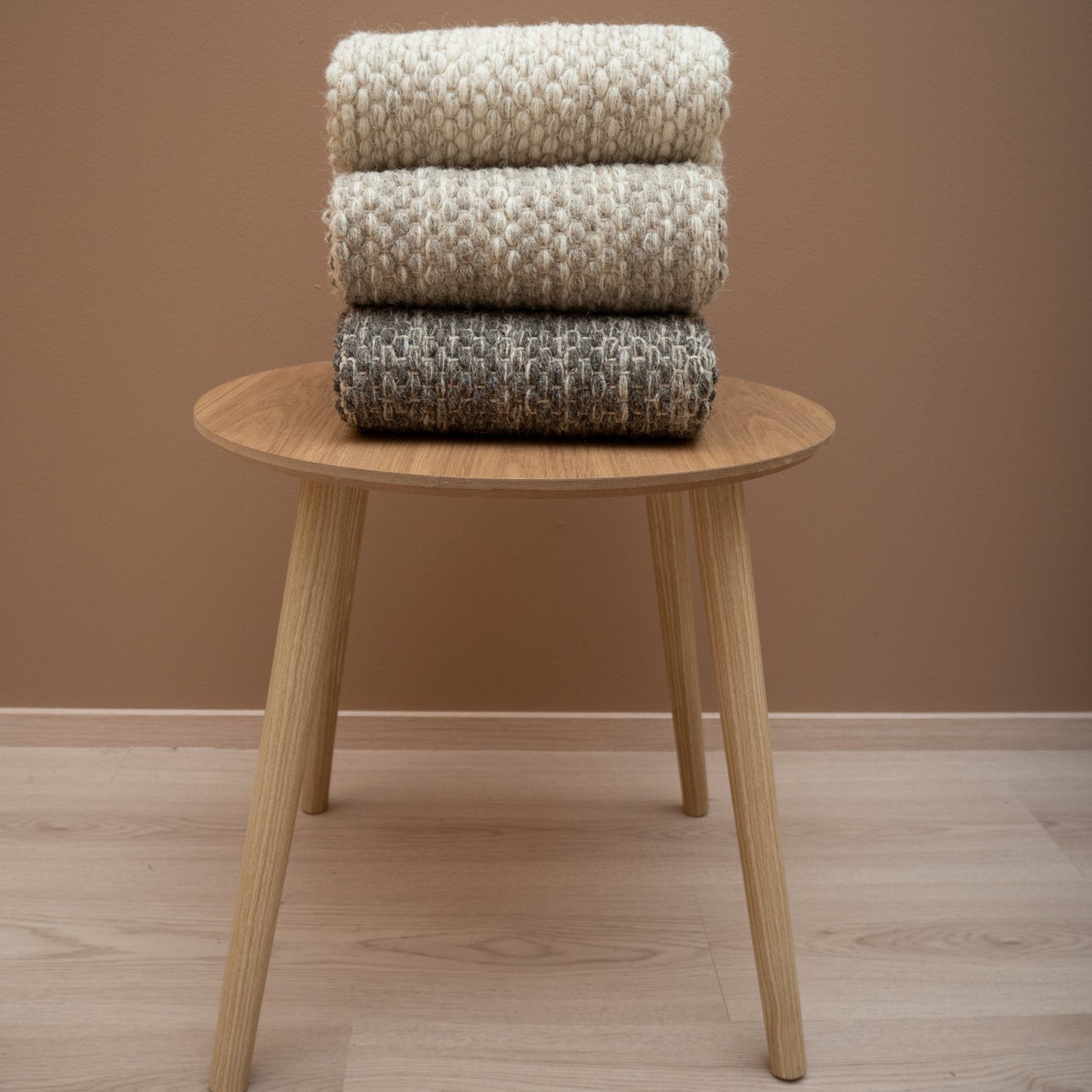 Käsinkudottu villamatto Oona on saatavana luonnollisen pehmeissä sävyissä. Kuvassa maton värit alhaalta katsottuna tummanharmaa, harmaa ja luonnonvalkoinen ylimpänä.