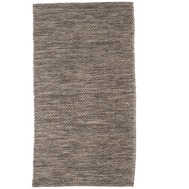 Oona-matto on tiivispintainen ja sileä villamatto, kuvassa tummanharmaa väri.