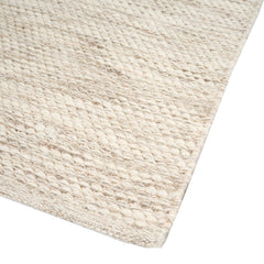 Lähikuvassa luonnonvalkoisen Oona-villamaton sileä ja tiivis pinta. Oona-villamatossa on pelkistetty meleerattu kuosi.