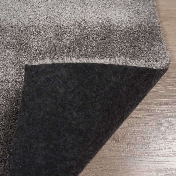 Roihu-matossa on pehmeä huopapohja, joka on helposti käsiteltävä ja sopii kaikille lattiapinnoille - myös lattialämmitteisille. Kuvassa vaaleanharmaa Roihu-matto ja sen huopapohja.