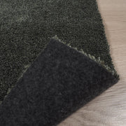 Roihu-matossa on pehmeä huopapohja, joka on helposti käsiteltävä ja sopii kaikille lattiapinnoille - myös lattialämmitteisille. Kuvassa tummanvihreä Roihu-matto ja sen huopapohja.