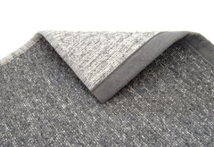 Saima-puuvillamatto on kaksipuoleinen. Lähikuva harmaan maton kääntöpuolesta. 