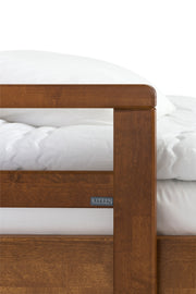 Pähkinäpetsattu, kestävästä koivusta valmistettu Seniori-sängyn sivulaitaan kiinnitettävä nousutuki.