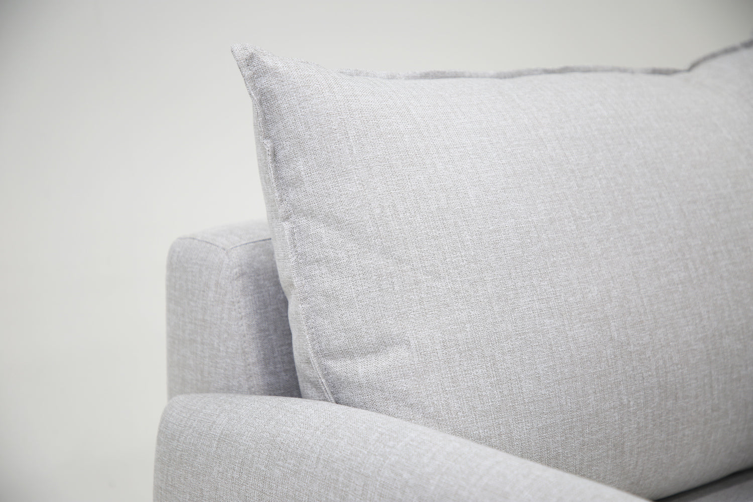 Lähikuva Stockholm-avokulmavuodesohvan vaaleanharmaasta Stark 607 -kangasverhoilusta. Selkätyynyn reunojen verhoilun viimestelevät kauniit tereet.