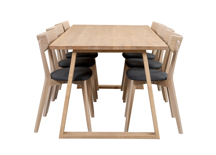 Swing-sarjan ruokailuryhmän valkovahattu koivupöytä on 190 x 90 cm kokoisella kannella ja yhtenäisillä viistejaloilla. Valkotammenvärisissä Ami-tuoleissa on harmaa kangasverhoiltu istuinosa.