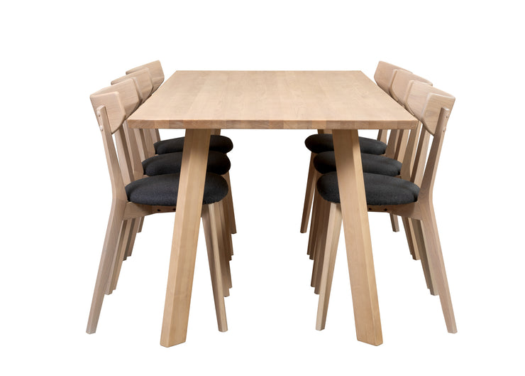 Swing-sarjan ruokailuryhmän valkovahattu koivupöytä on 190 x 90 cm kokoisella kannella ja vinoilla yksittäisillä puujaloilla. Valkotammenvärisissä Ami-tuoleissa on harmaa kangasverhoiltu istuinosa.