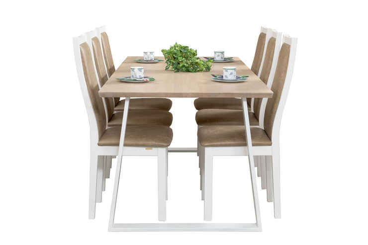Kuvassa on Swing-sarjan ruokailuryhmän pöytä, joka on 190 x 90 cm kokoisella valkovahatulla kannella ja valkoisilla metallisilla viistejaloilla. Valkoisissa Pohjola-tuoleissa on vaaleanruskea istuimen ja selkänojan nahkaverhoilu.
