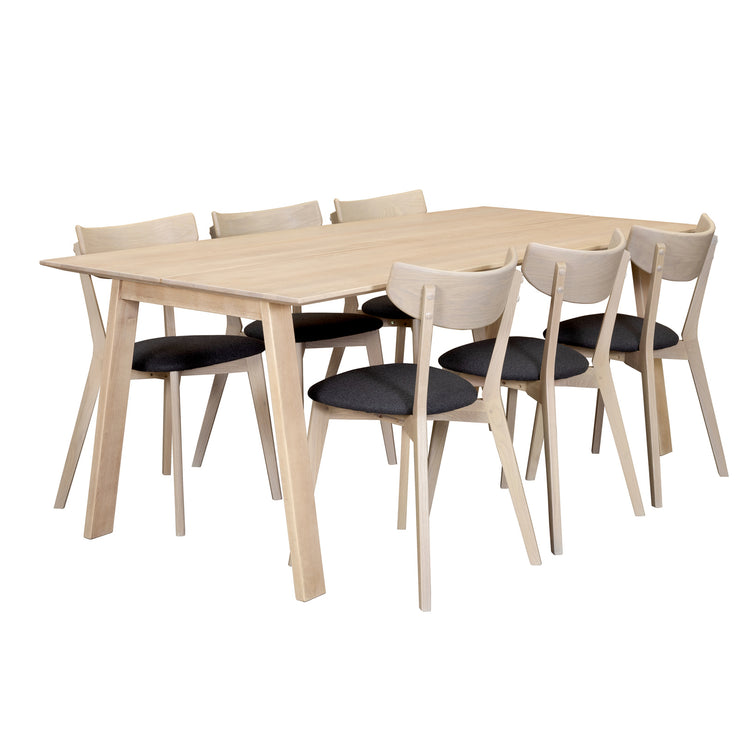 Tango/Ami -ruokailuryhmän valkovahattu Tango-koivupöytä on 200 x 90 cm kokoinen. Valkotammenvärisissä Ami-tuoleissa on harmaa kangasverhoiltu istuinosa.
