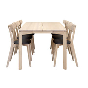 Twist/Ami -ruokailuryhmän valkovahattu Twist-koivupöytä on 190 x 90 cm kokoinen. Valkotammenvärisissä Ami-tuoleissa on harmaa kangasverhoiltu istuinosa.