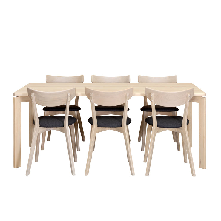 Twist/Ami -ruokailuryhmän valkovahattu Twist-koivupöytä on 190 x 90 cm kokoinen. Valkotammenvärisissä Ami-tuoleissa on harmaa kangasverhoiltu istuinosa.