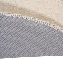 Pyöreä Usva-matto valkoisena. Lähikuvassa nukkamaton liukumaton lateksipohja.