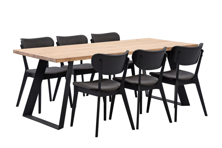 Venla-ruokapöytä 200 x 90 cm antiikinruskealla kannella ja vinoilla mustilla metallijaloilla sekä mustat Marina-tuolit.