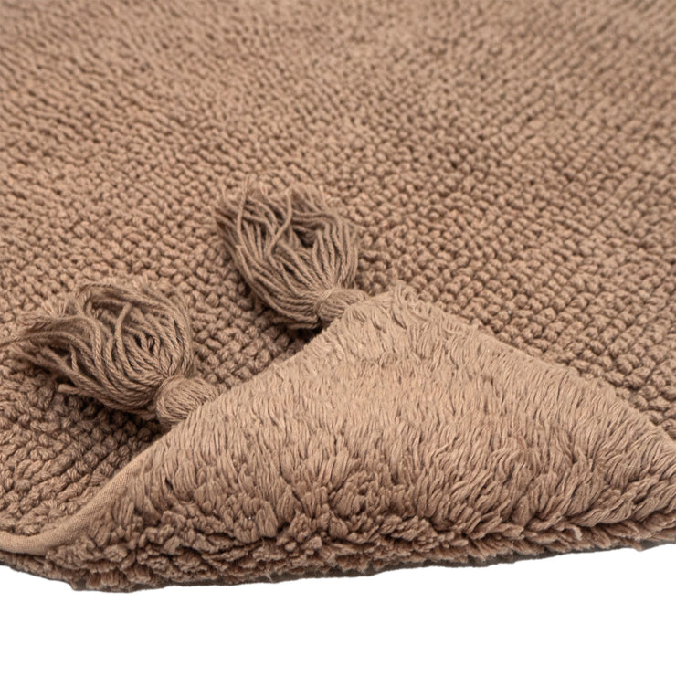 Vilma-kylpyhuoneen maton beige väri. Molemmin puolin pidettävässä matossa ihastuttavat puolien erilaiset pinnat ja isot hapsut.